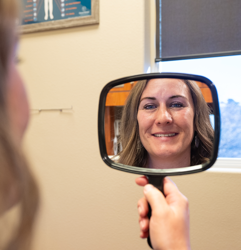 Dr. Yelle's patient smiling into a mirror