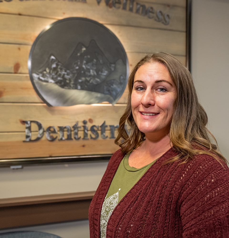 Dr. Yelle's patient smiling in front of the office sign